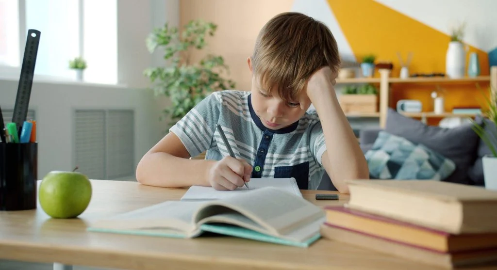 Child focusing hard while trying to complete a task alone