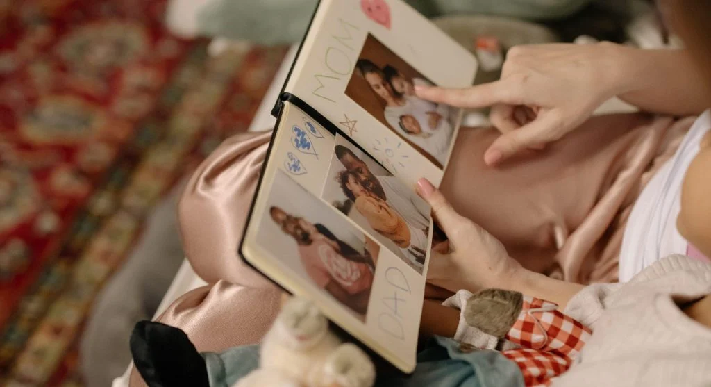 Parent and child using family photos to retell familiar family stories