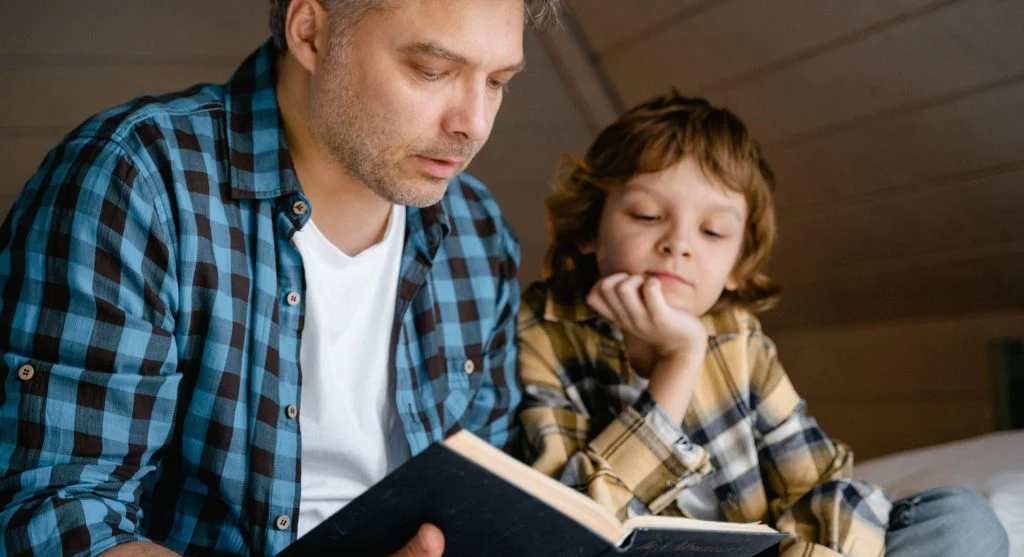 Parent and child sharing a quiet reading moment on a slow weekend morning