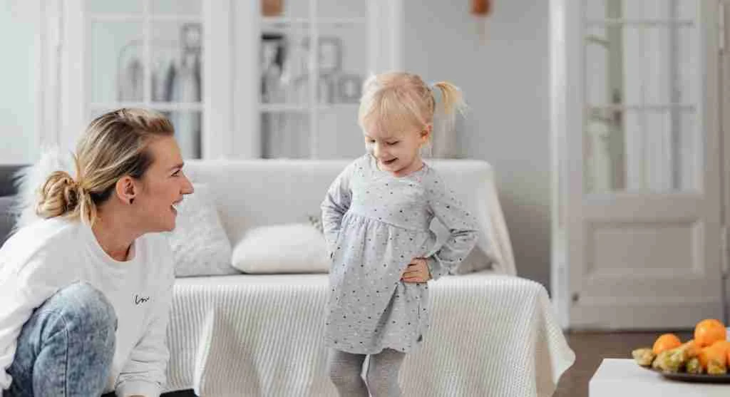 Child laughing while repeating a favorite joke to family members