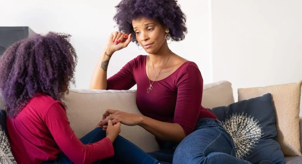 Parent and child talking privately at home after an earlier public question