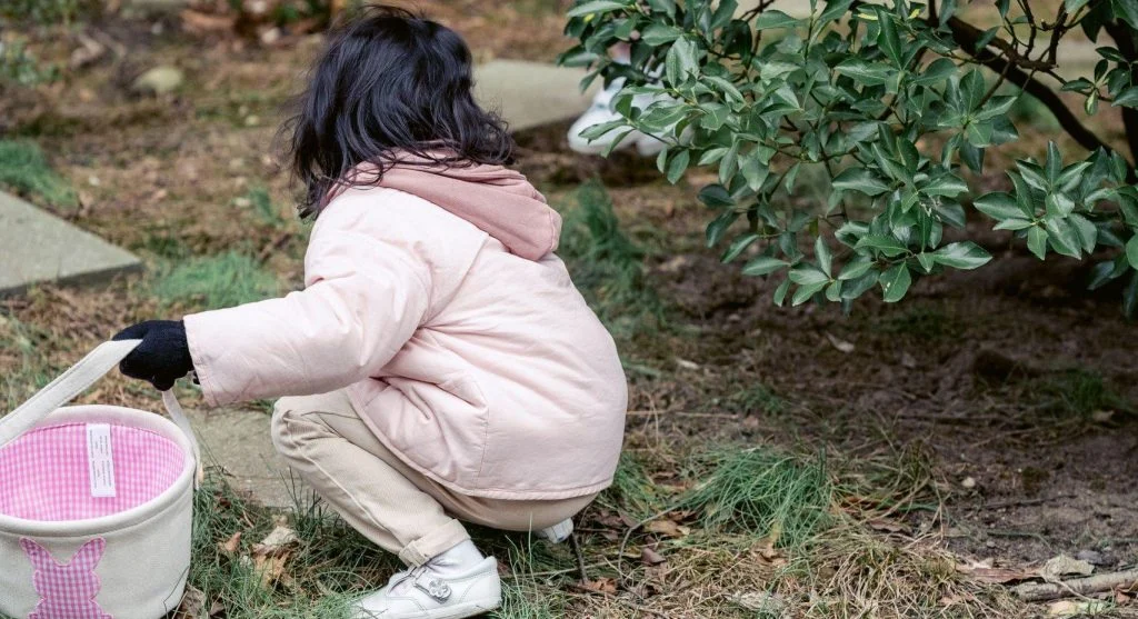 Child carefully searching for small objects during an outdoor walk